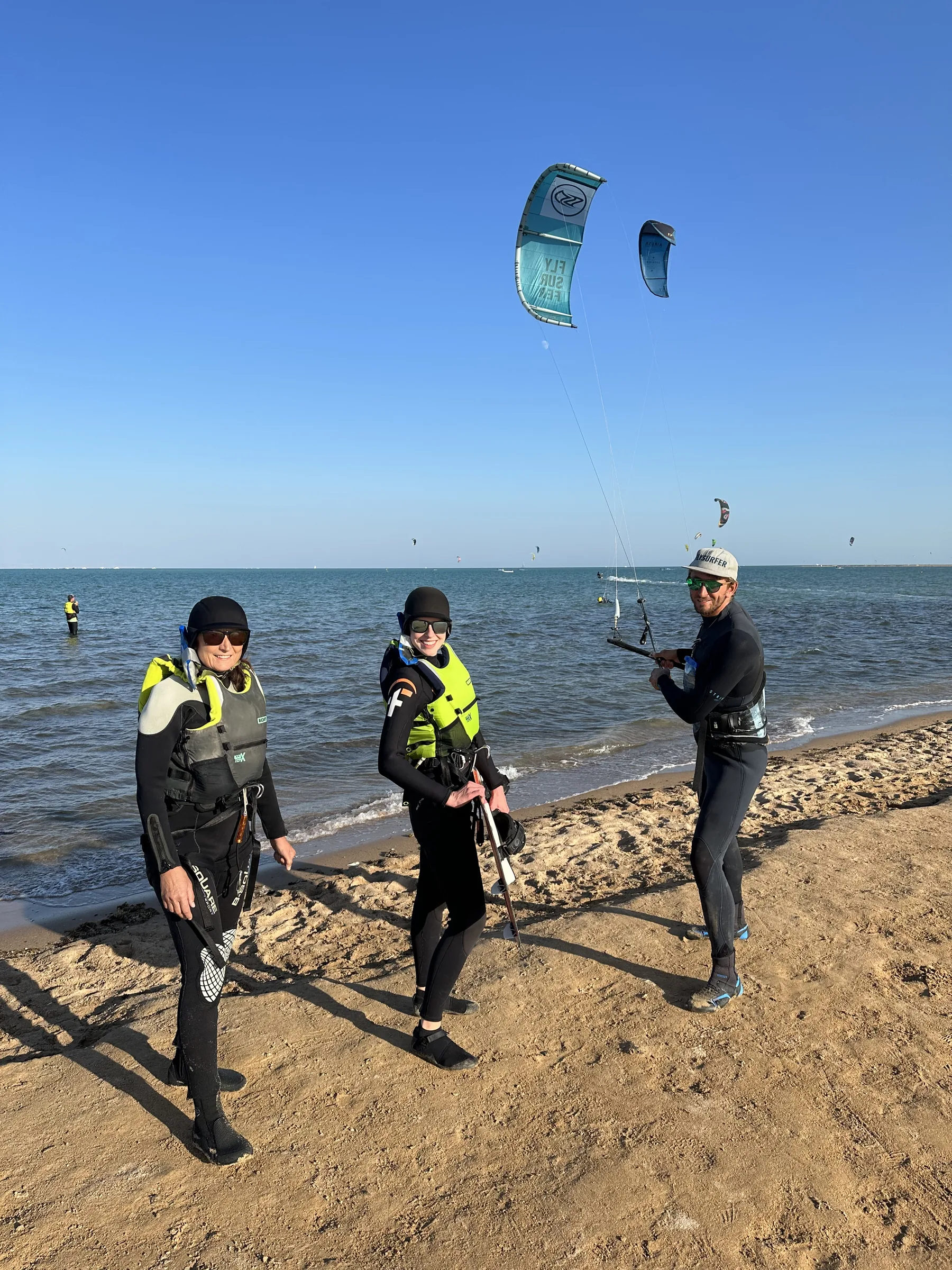 Začátečnice se učí ovládat kite s instruktorem v mělké výukové části laguny El Gouny