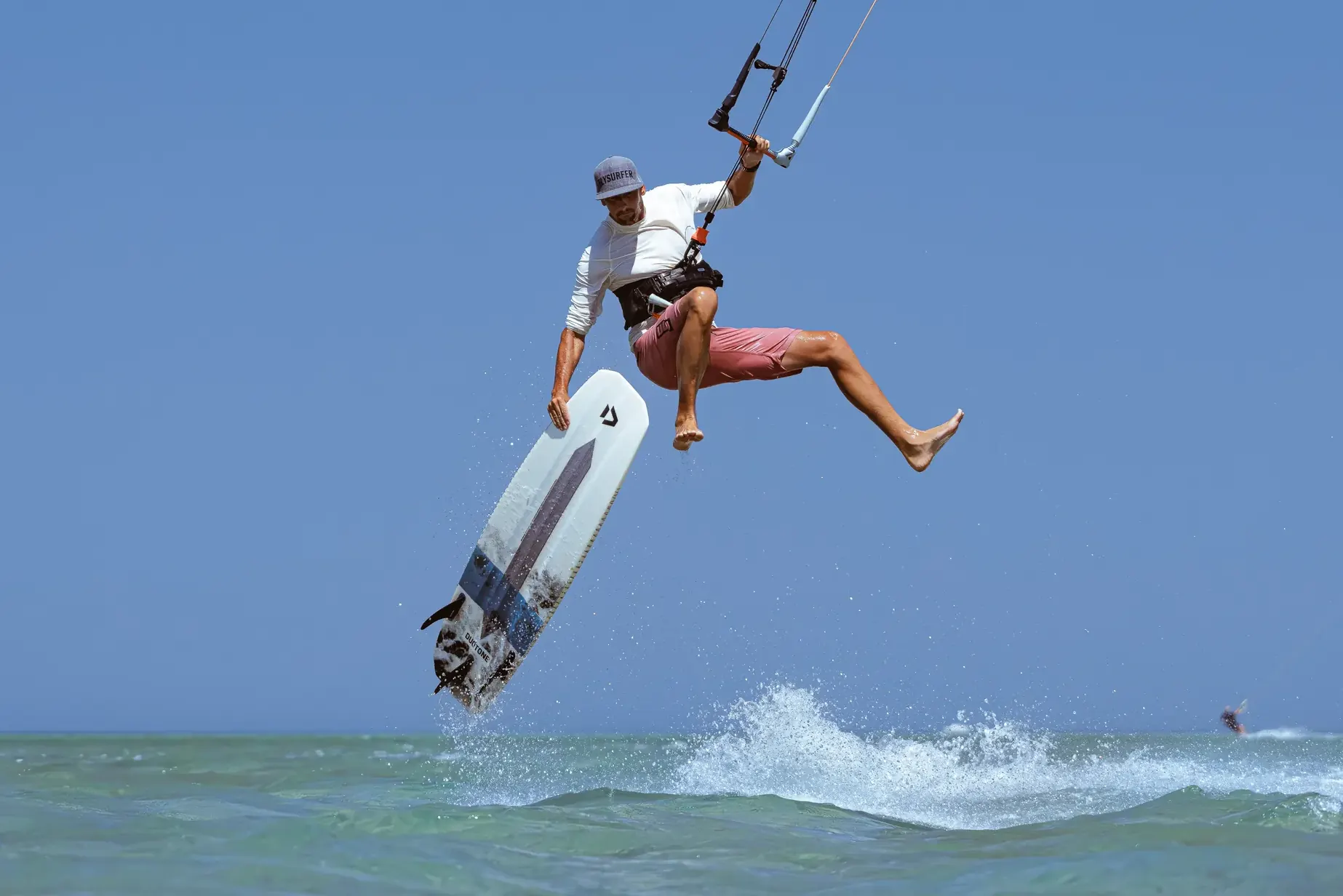 Strapless kiter s board grabem na laguně s rovnou vodou v El Gouně