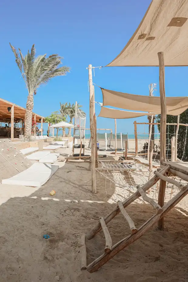 Stínicí plachty nad dřevěným hřištěm na písku v beach clubu SALT v El Gouně