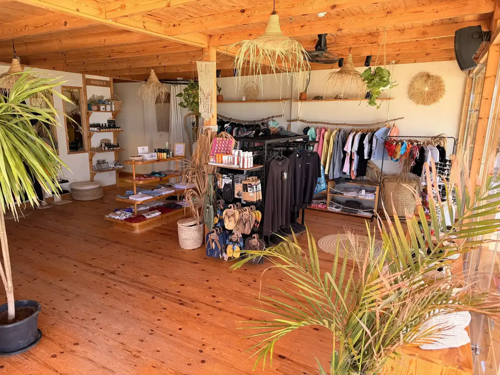 Uvnitř kite obchodu Kitepower na pláži v El Gouně — butik s dřevěnou podlahou, vybavením Flysurfer, oblečením a výhledem na moře