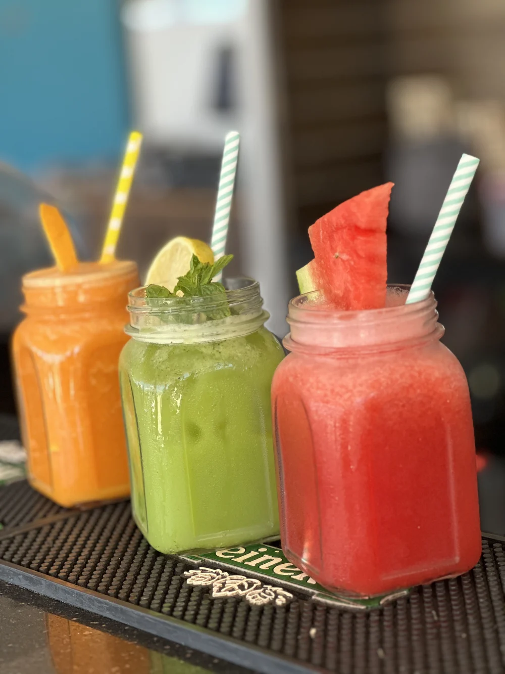 Mrkvové, zelené a melounové smoothie ve sklenicích na plážovém baru Kitepower v El Gouně